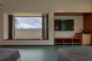 Modern residential interior with minimalist design, featuring large windows, natural light, and a blend of modern materials.