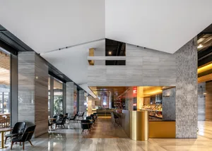 A modern restaurant bar with concrete walls and a bar counter.