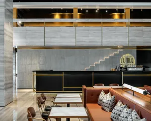 Modern restaurant interior with concrete, glass, and metal elements.