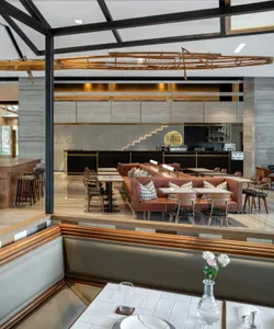 Modern restaurant interior with wood, metal, and leather furniture and decor