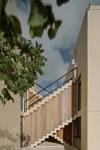 Modern, wooden staircase with black metal railing.
