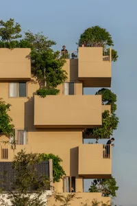 A modern residential building with concrete exterior and glass windows.