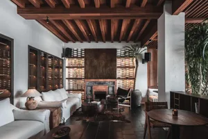 Industrial living room with wooden furniture and exposed beams.