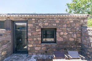 A minimalist stone exterior with a door and window.