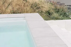 Concrete poolside area with minimalist design elements.