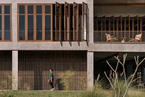 Modern building exterior featuring concrete, glass, and wooden elements.
