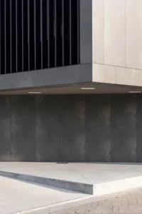 Detailed view of a modern building featuring concrete blocks and large windows.