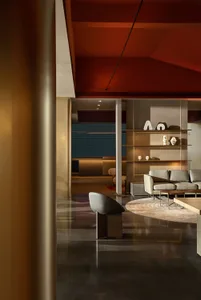 A modern living room featuring a mix of metal and leather materials, including a sofa, coffee table, and decorative shelving.