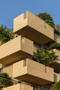 Modern residential building with concrete balconies and glass windows.