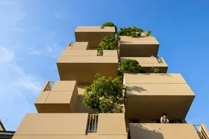 一座現代住宅建築，採用清水混凝土結構並搭配綠色植物。