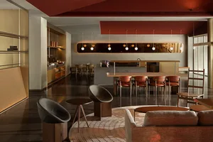 A modern residential living area featuring concrete walls and wooden furniture.