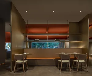 Modern restaurant interior with wooden furniture, glass partitions, and metal accents.