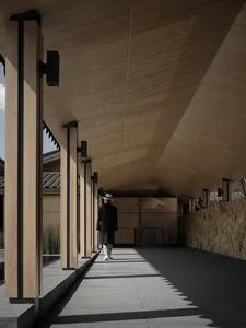 Industrial-looking hallway with wooden columns and ceiling, steel accents, and person walking.