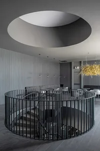 工業風格樓梯搭配金屬扶手，天花板設有圓形開口。