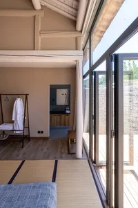 A minimalist residential interior featuring wooden flooring and glass walls, showcasing modern design elements.