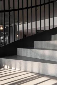 Concrete stairs with a minimalist design and black metal railing.