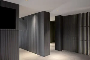 A modern office lobby featuring metallic planks on the walls.