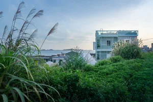 Modern glass house overlooking a coastal landscape