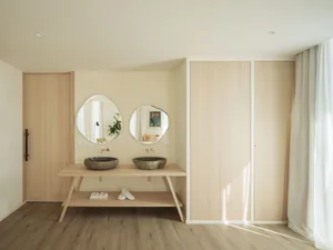 Minimalist kitchen with pristine white appliances, wood laminate flooring, and a sleek, modern design.