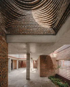 Modern building with a curved, brick ceiling and brick walls.