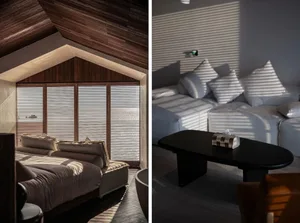 Modern bedroom featuring wooden ceiling, frosted glass windows with wooden blinds, and comfortable seating area with pillows