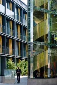 A modern building with glass, metal, and yellow curtains.