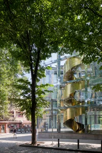 Modern building with glass facade and spiral staircase.