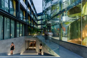 A modern architectural space featuring glass walls and concrete floors.