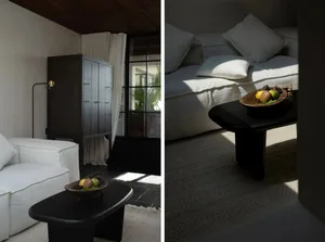 Modern minimalist living room with white sofa, black cabinet, and coffee table with decorative bowl.