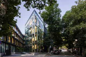 A modern, glass-and-steel office building in an urban setting.