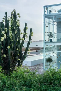 A modern residential casino with glass walls overlooking the ocean.