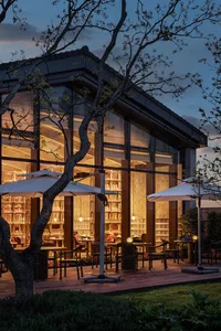 Modern restaurant exterior with glass walls at dusk