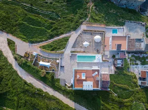 Aerial view of a modern residential roof deck featuring concrete and metal elements with a glass swimming pool and lounge are