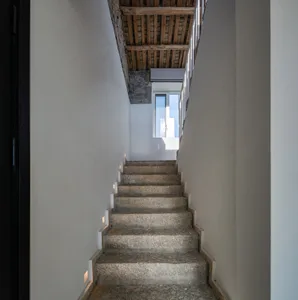 Concrete staircase with walls and wooden beams in an industrial design setting.