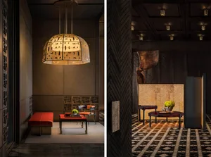 Industrial-style lobby featuring metallic pendant lighting, textured walls, and dark furnishings.