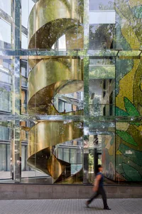 A modern building with a spiral staircase made of glass.