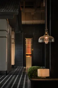 Cozy modern hotel lobby with wooden paneled walls and warm lighting.