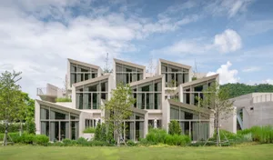 A modern residential building with concrete walls and large windows.