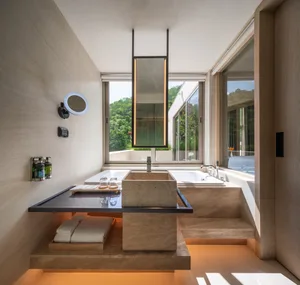 Modern bathroom with marble sink, tub, and floor, surrounded by large windows.