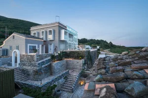 Modern residential exterior with stone, concrete, glass and landscaping