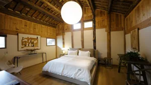 A spacious residential interior with exposed wood beams and industrial features.