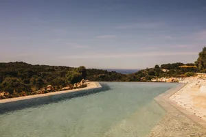 An infinity pool overlooking a scenic landscape.