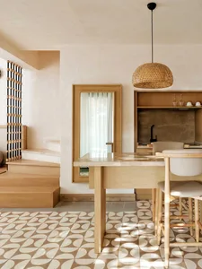 A minimalist residential interior featuring wood, marble, and patterned tiles on the floor.