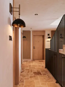 A modern corridor with stone flooring and wooden doors.