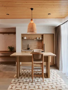 Modern kitchen with wooden countertop and marble backsplash, featuring a pendant light with a woven texture