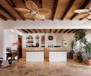 A modern reception desk with a stone countertop and wooden beam ceiling.