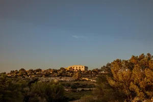 Residential buildings nestled on a stone hillside.