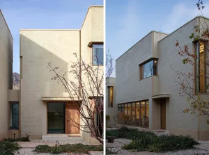 Modern house with concrete exterior and large windows.