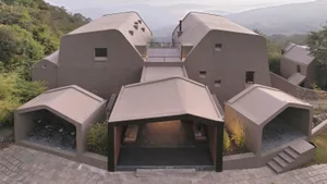 Modern residential building with concrete exterior and geometric shapes.