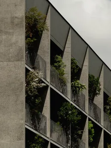 Sustainable building exterior with green roofs and gardens integrated into the design.